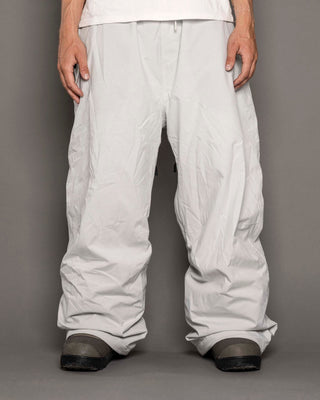 White pants worn by a person on a gray background