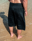 BUSI Biggie Shorts Black denim shorts, back view on model on the beach