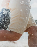 BUSI Biggie Shorts Off White denim shorts, lifestyle shot by the water
